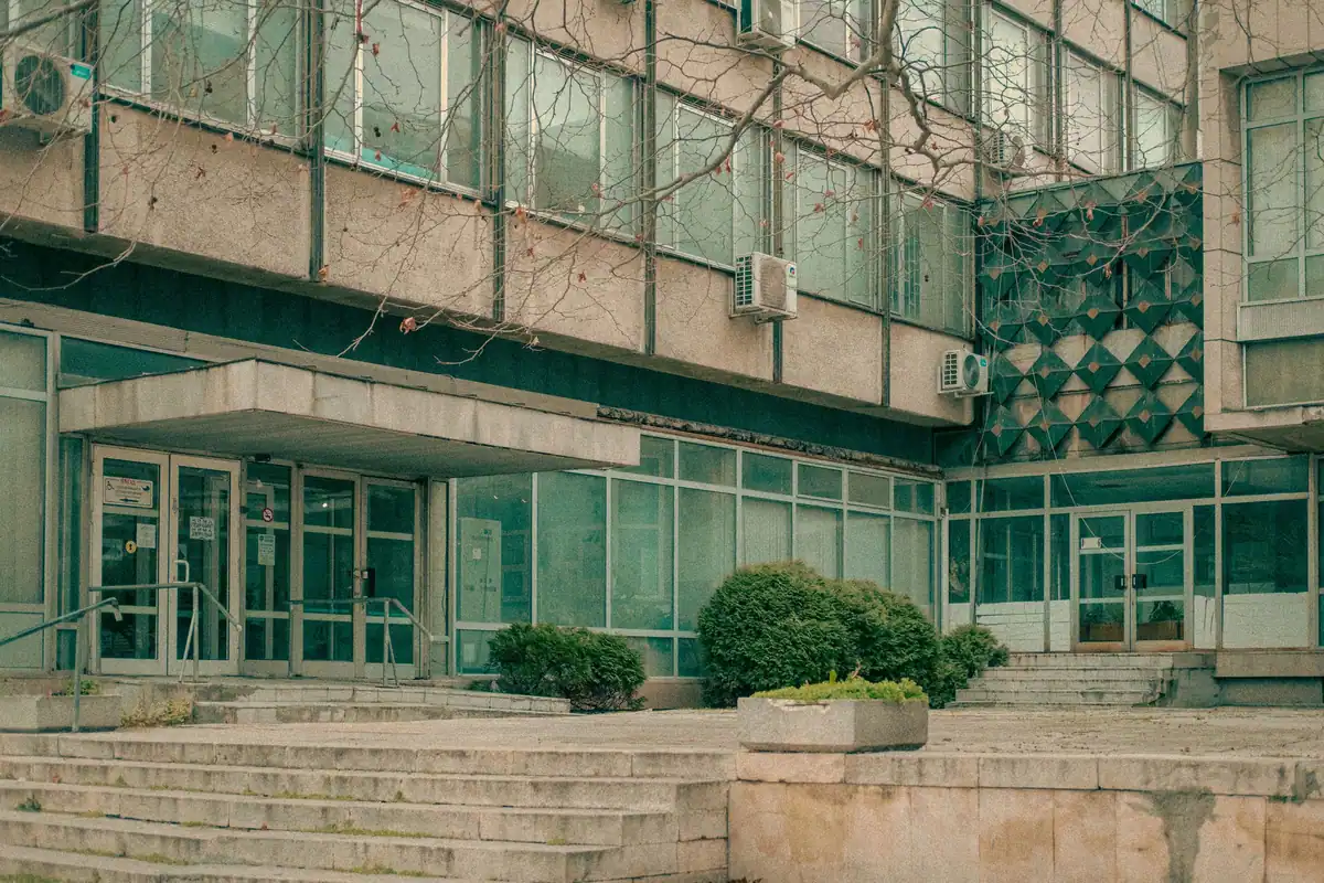 Clădire administrativă cu fațadă de sticlă și trepte largi, unde se plătesc taxele locale